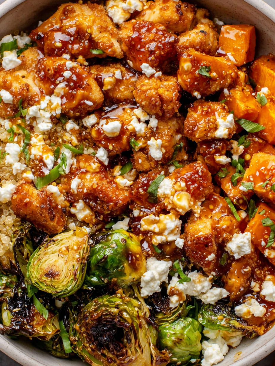 A bowl of chicken with feta cheese and sauce.