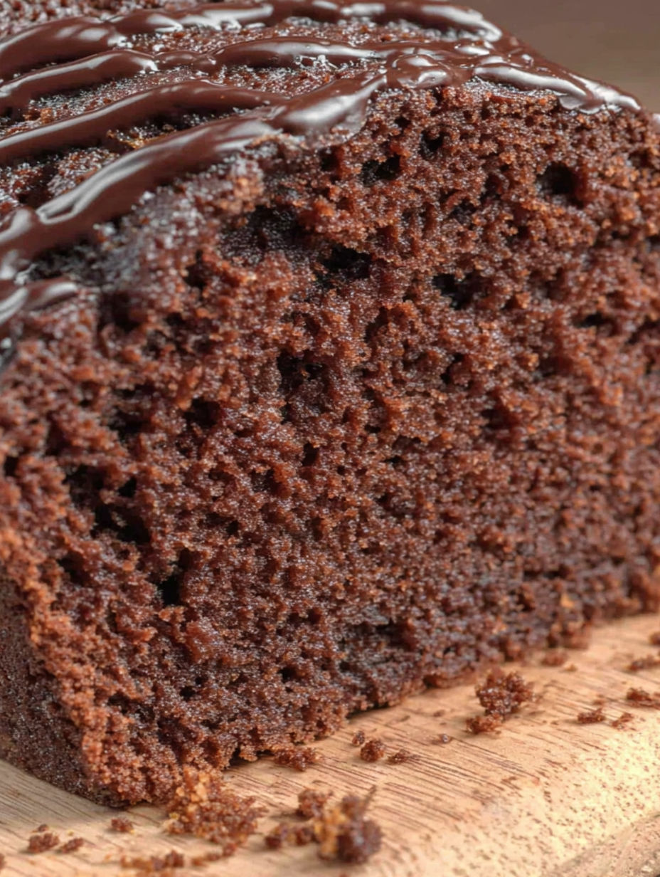 A slice of chocolate cake with chocolate drizzle.