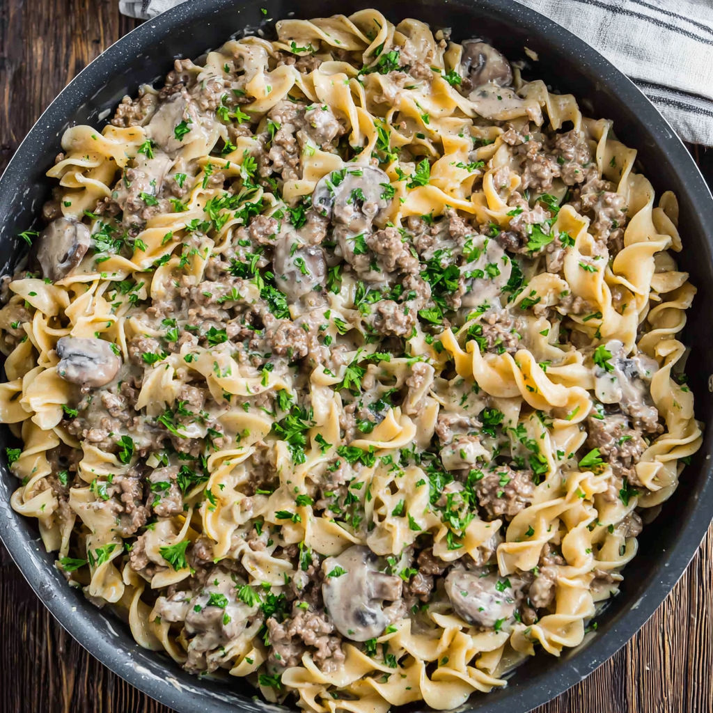 A bowl of pasta with meat and mushrooms.