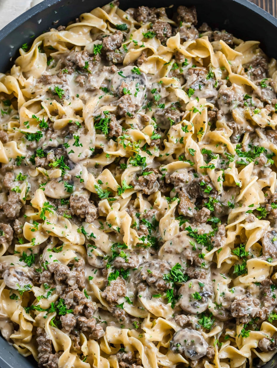 A bowl of pasta with meat and vegetables.