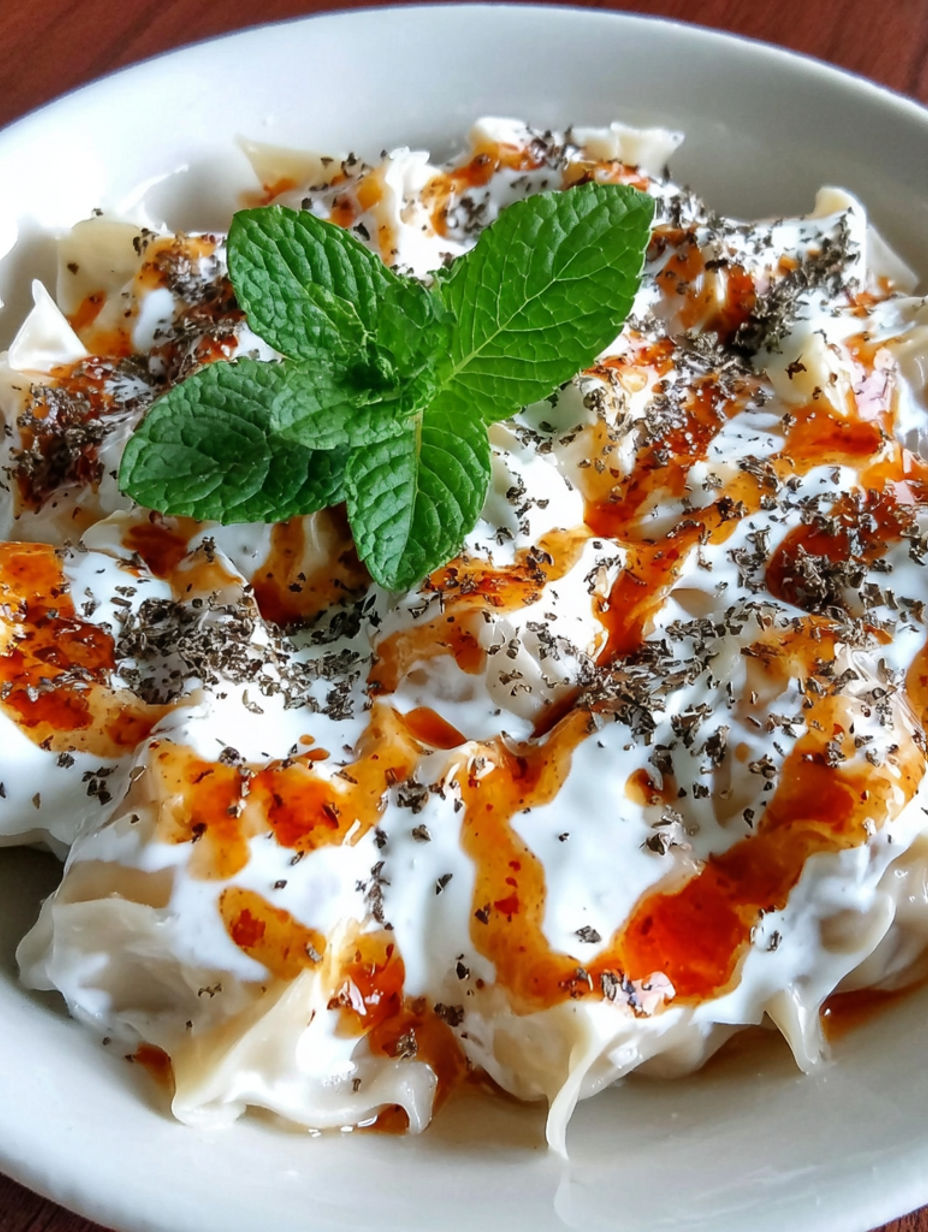 A bowl of food with mint leaves and orange sauce.