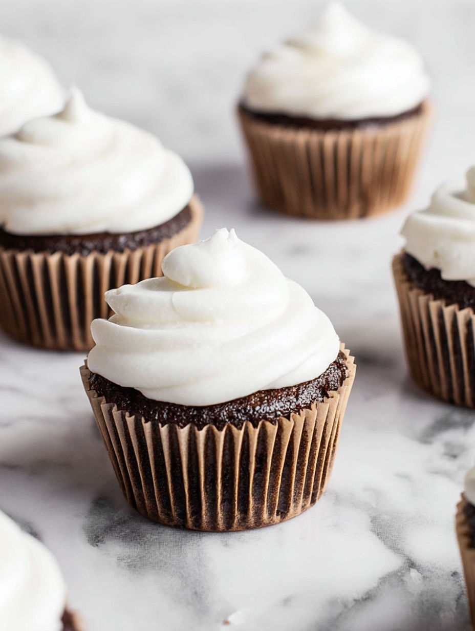 A cupcake with white frosting and chocolate frosting.