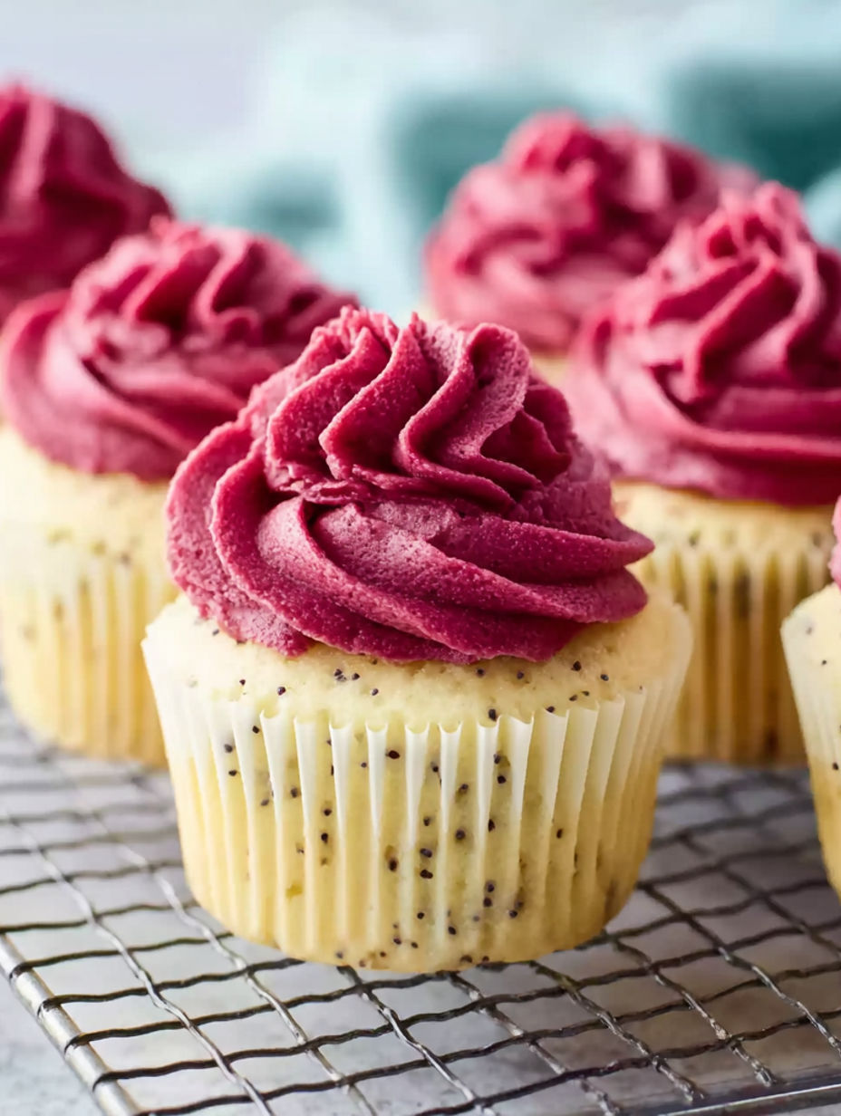 Three cupcakes with red frosting and yellow sprinkles.