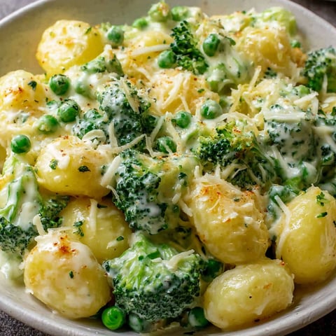 A bowl of food with potatoes and broccoli.