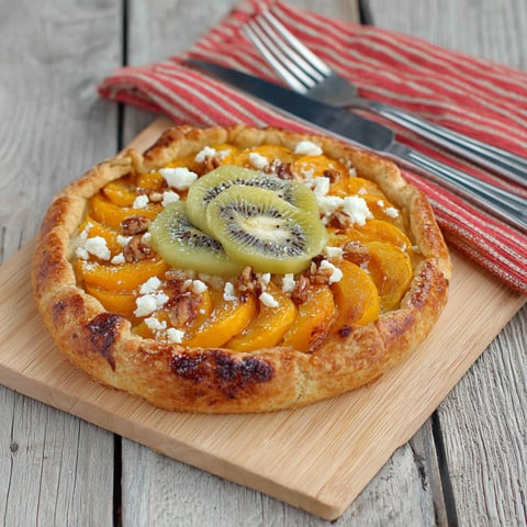 A slice of pizza with kiwi and blue cheese.
