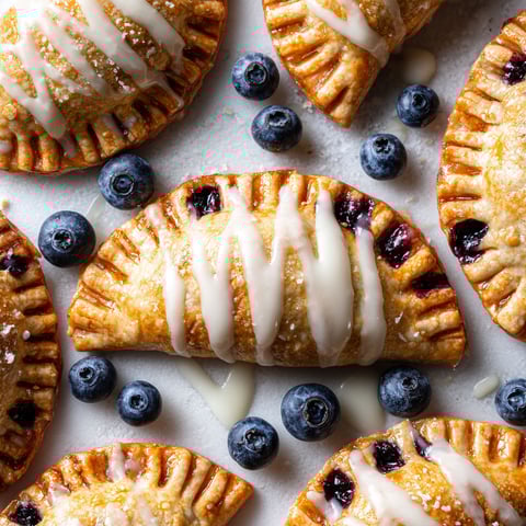 Blaubeer-Handpies with white icing and blueberries.