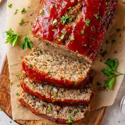 A stack of meat with green toppings.