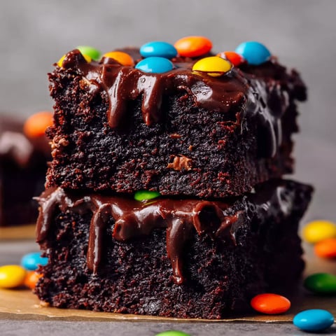 A close up of a chocolate fudge brownie with M&M's.