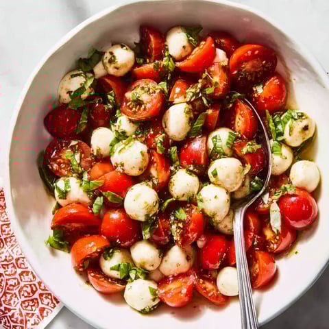A bowl of Caprese salad with tomatoes and mozzarella.