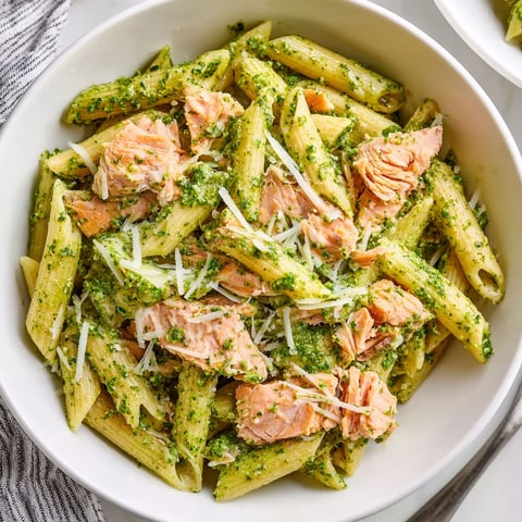 A bowl of pasta with salmon and pesto.