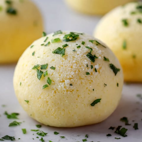 A yellow ball of food with green herbs on top.