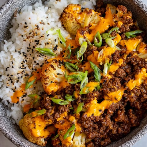 A bowl of food with rice, cauliflower, and chili.
