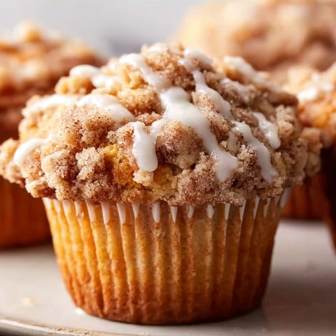Two muffins with white frosting and brown sugar.