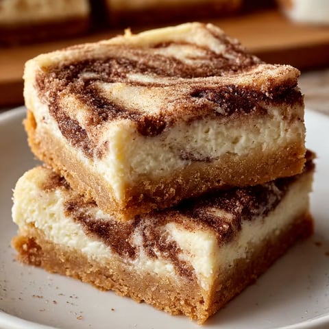 A stack of cinnamon swirl cheesecake bars.